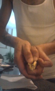 Prying open the protective outer shell of the mango seed by hand